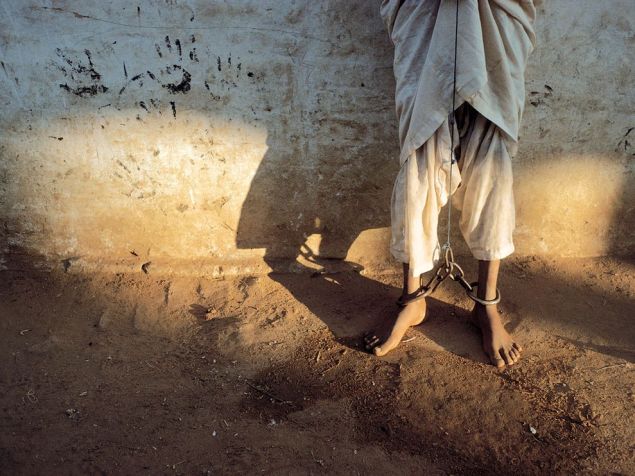 Chained Feet, Sudan Photograph by Reza  This Month in Photo of the Day: Images From National Geographic Books  "I saw his feet, scarred by chains that also bound his hands. His eyes were resigned, his violence contained."—Reza   From the National Geographic book Reza War + Peace, 2009  