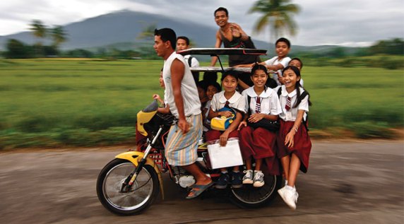 Philippines: Children cram onto a small taxi called a "tricycle" for their ride to school. It costs them less than a dollar, but that's a lot for poor families to have to pay.(SOURCE: compassion.com)
